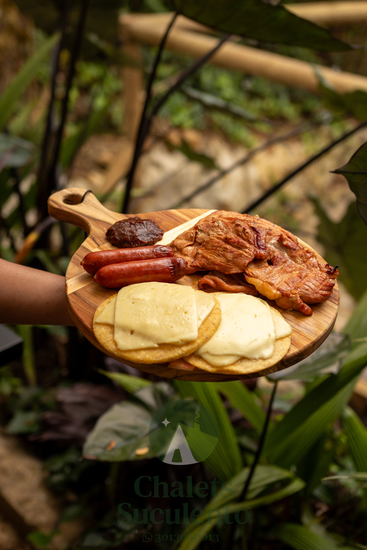 Tabla de asado con carnes, salchichas y arepas con queso
