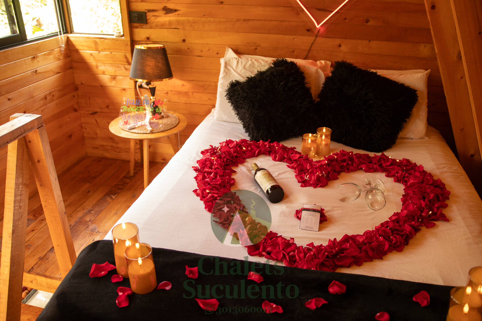 Cama decorada con pétalos, velas y vino para una ocasión especial