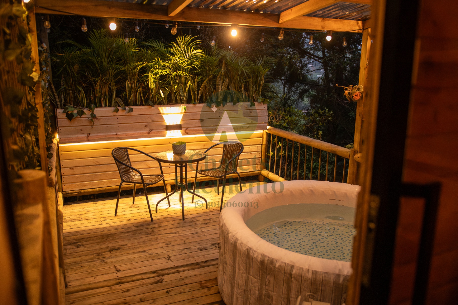 Terraza privada con jacuzzi iluminada por luces cálidas de noche