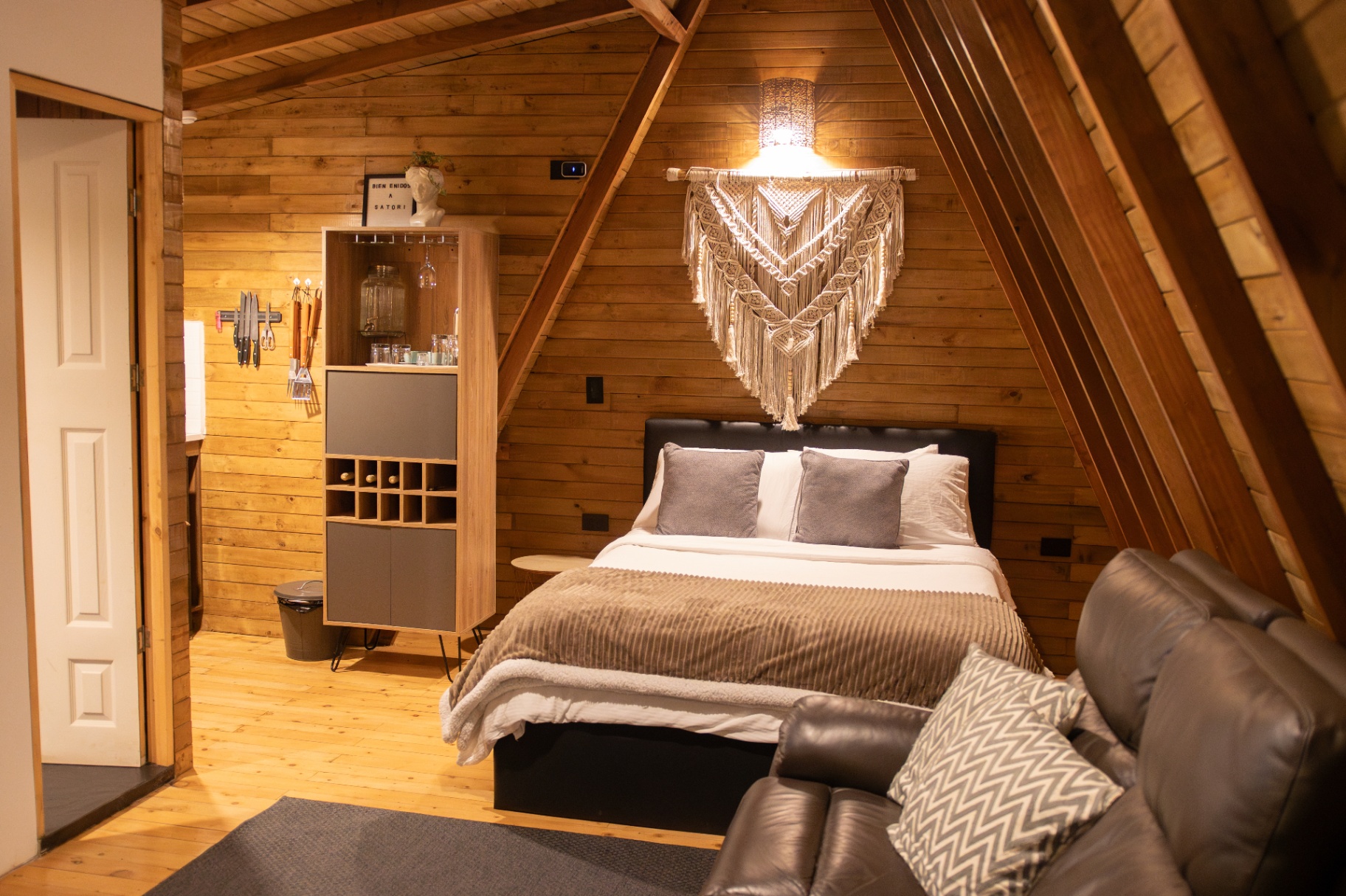 Interior acogedor de chalet con cama, madera natural y decoración artesanal